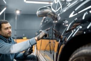 Mécanicien montrant comment enlever une rayure de carrosserie